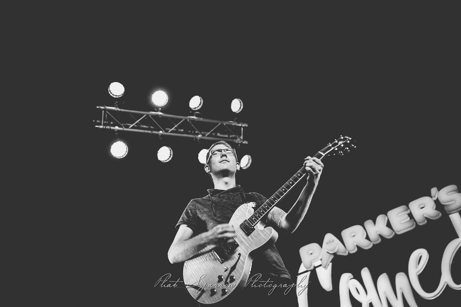 Ryno Zeelie performing a guitar solo on stage under bright lights